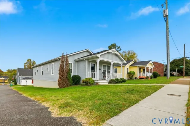a front view of a house with a garden and trees