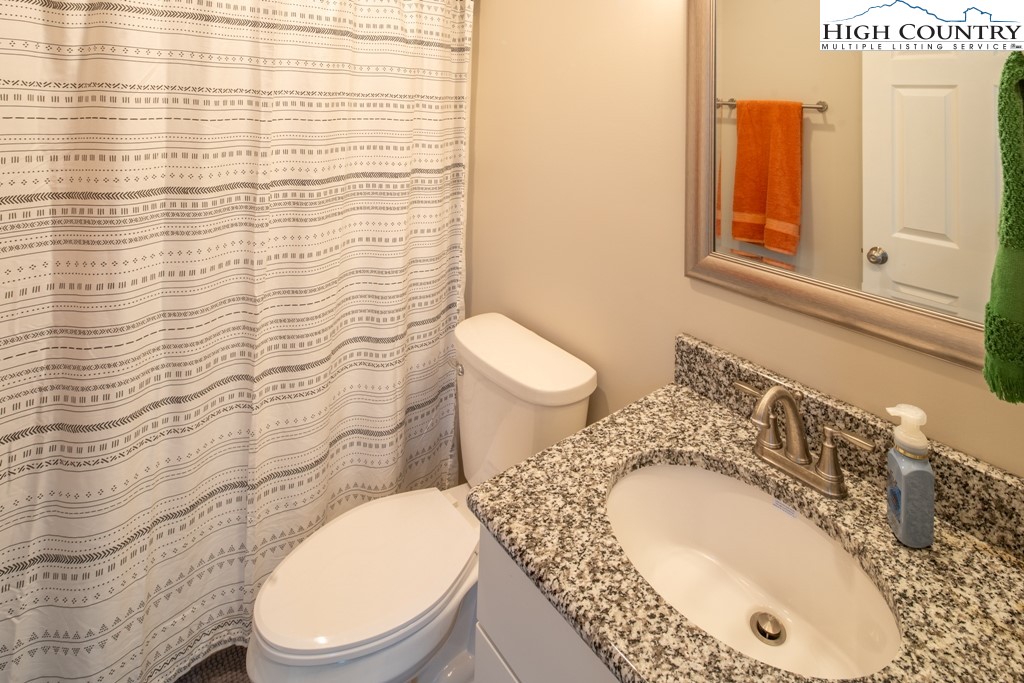 575 Townhomes Place, Unit 34 Boone, NC 28607 - Photo 15 of 32 a bathroom with a granite countertop toilet sink and mirror