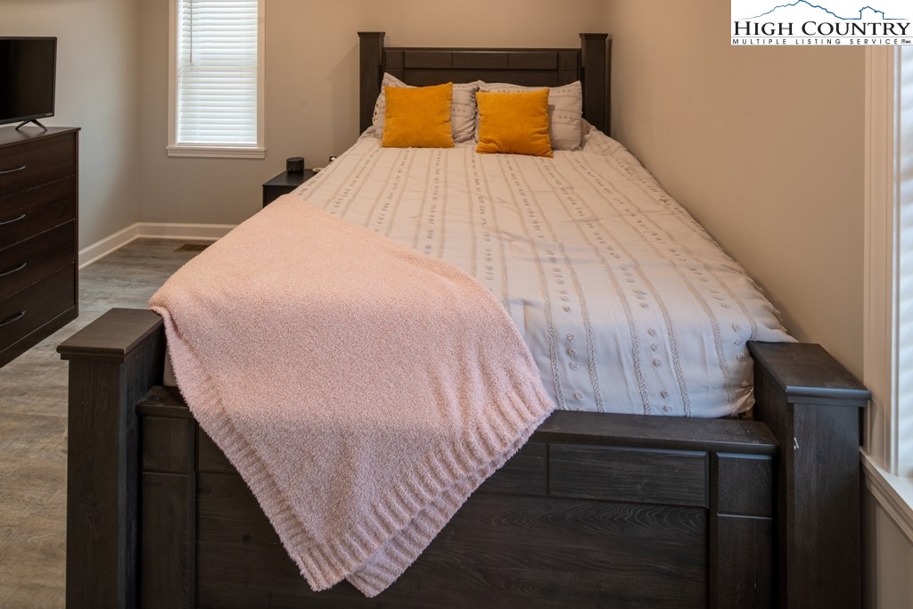 575 Townhomes Place, Unit 34 Boone, NC 28607 - Photo 19 of 32 a bed sitting in a bedroom next to a window with wooden floor