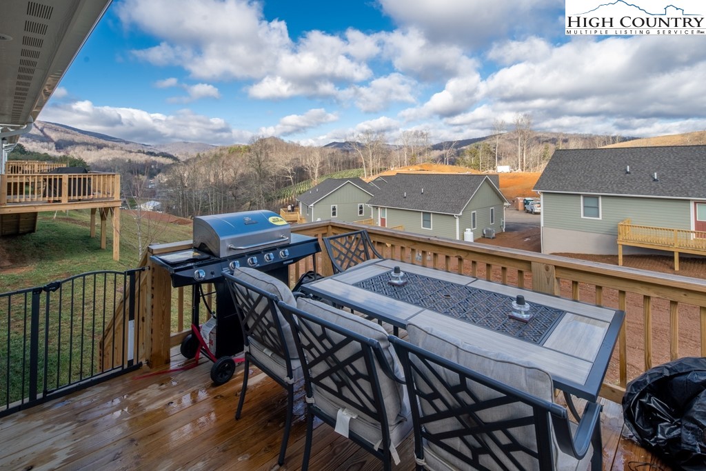 575 Townhomes Place, Unit 34 Boone, NC 28607 - Photo 24 of 32 a view of a roof deck with table and chairs with wooden floor and fence