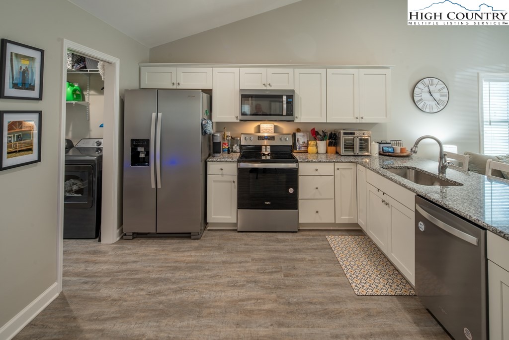 575 Townhomes Place, Unit 34 Boone, NC 28607 - Photo 9 of 32 a kitchen with stainless steel appliances granite countertop a refrigerator a stove a sink and a refrigerator with white cabinets