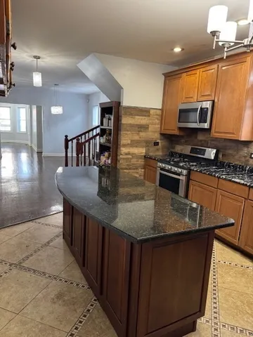 a kitchen with stainless steel appliances granite countertop a stove a sink dishwasher and microwave