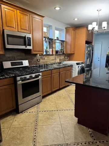 a kitchen with stainless steel appliances granite countertop a stove sink microwave and refrigerator