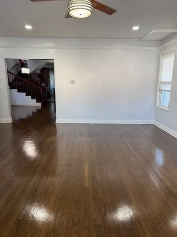 an empty room with wooden floor and natural light