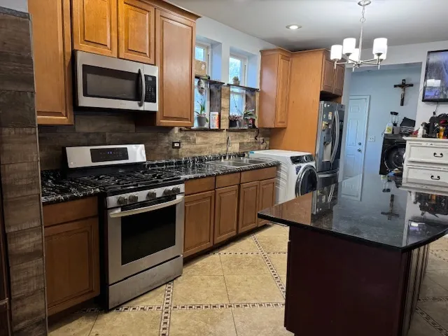 a kitchen with stainless steel appliances granite countertop a sink stove and microwave