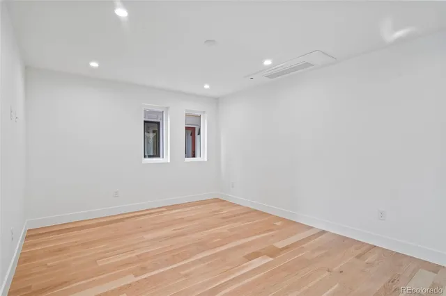 a view of empty room with wooden floor