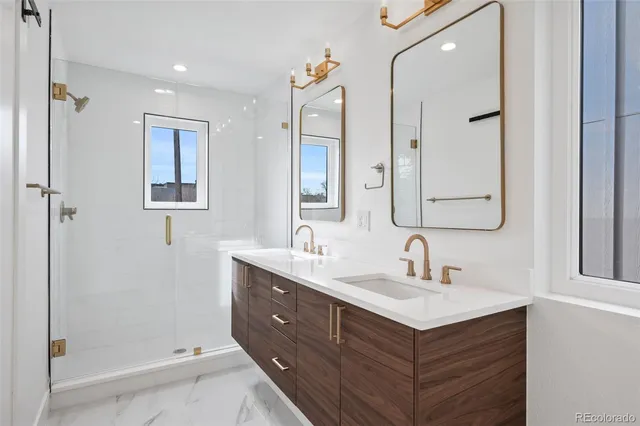 a bathroom with a double vanity sink mirror and shower