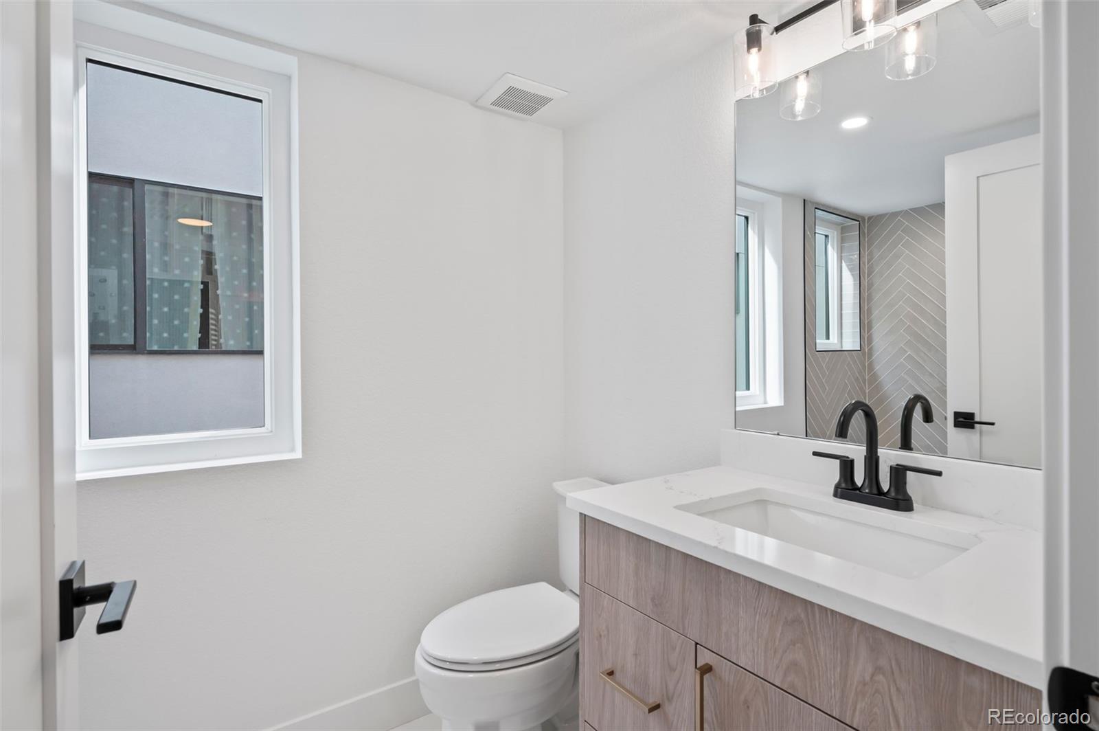 2451 Lawrence Street, Unit 2 Denver, CO 80205 - Photo 28 of 48 a bathroom with a sink a toilet and shower