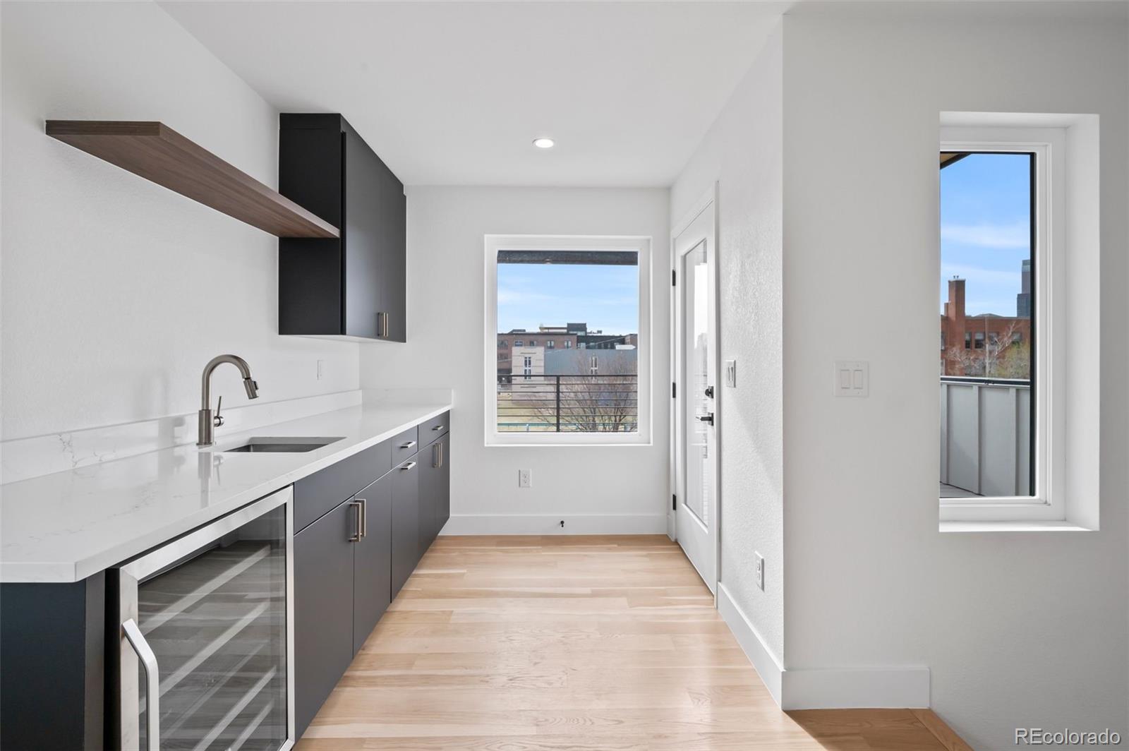 2451 Lawrence Street, Unit 2 Denver, CO 80205 - Photo 31 of 48 a large white kitchen with sink and mirror