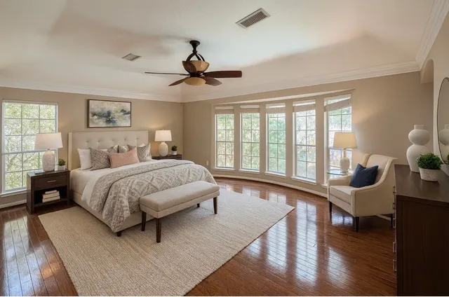 a spacious bedroom with a bed a couch and a large window
