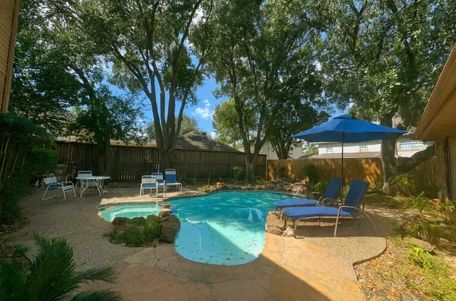 an outdoor sitting area with couch and umbrella