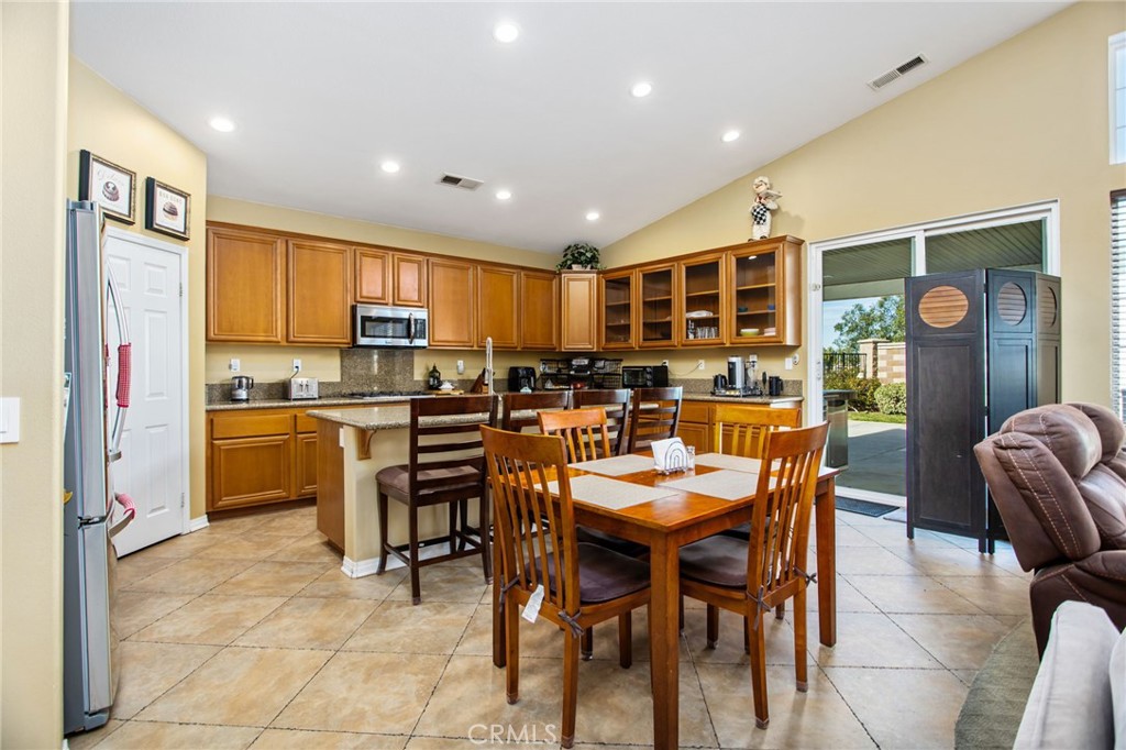 31677 Middlebrook Lane Menifee, CA 92584 - Photo 13 of 42 a dining room with stainless steel appliances kitchen island granite countertop a table and chairs