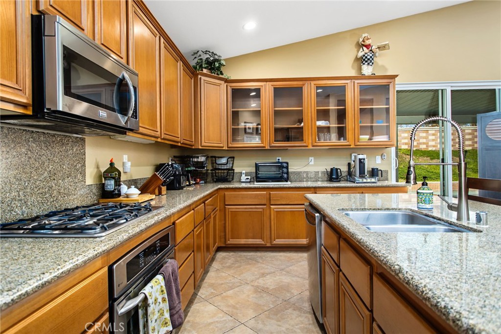 31677 Middlebrook Lane Menifee, CA 92584 - Photo 15 of 42 a kitchen with stainless steel appliances granite countertop a sink and a stove