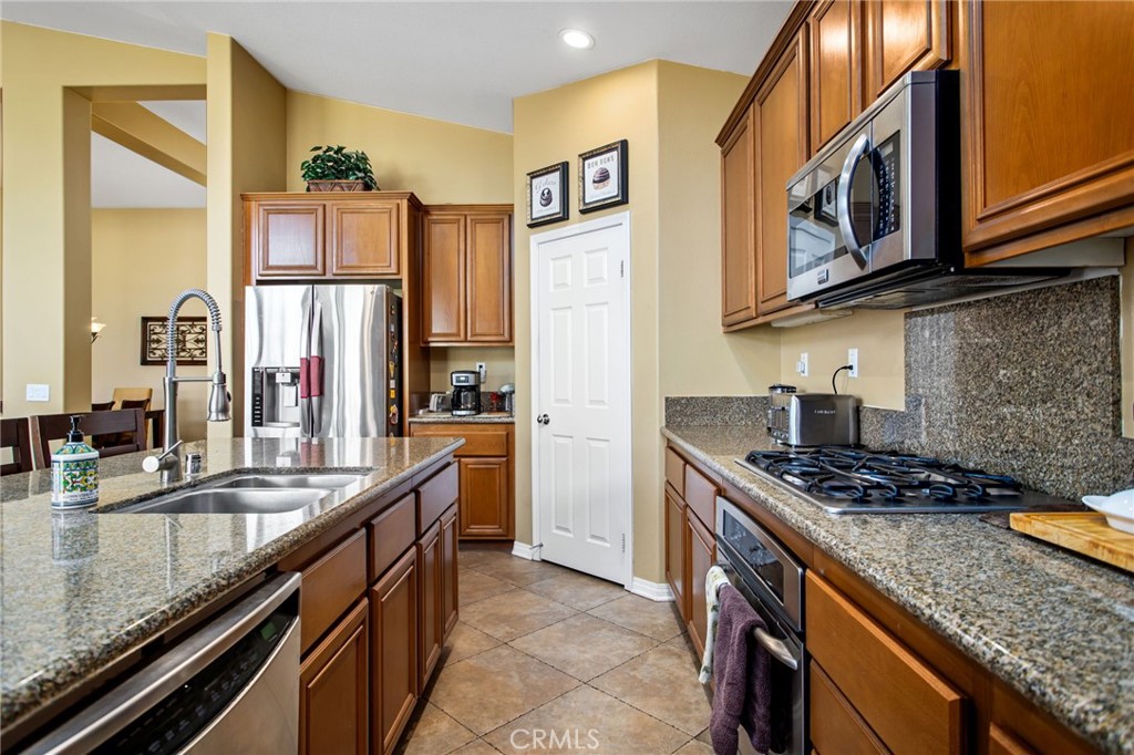 31677 Middlebrook Lane Menifee, CA 92584 - Photo 16 of 42 a kitchen with stainless steel appliances granite countertop a sink stove and refrigerator