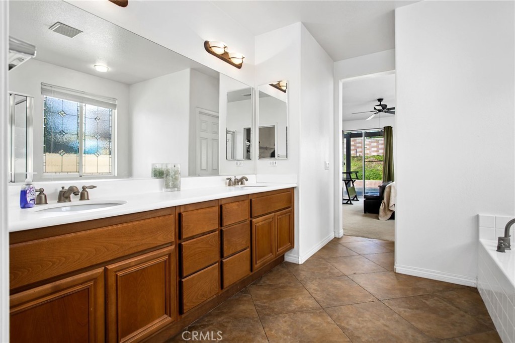 31677 Middlebrook Lane Menifee, CA 92584 - Photo 21 of 42 a spacious bathroom with a double vanity sink a mirror and a bathtub