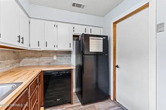 a kitchen with granite countertop a refrigerator and cabinets