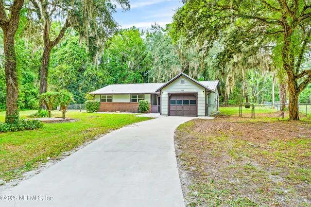 a front view of a house with a yard and trees