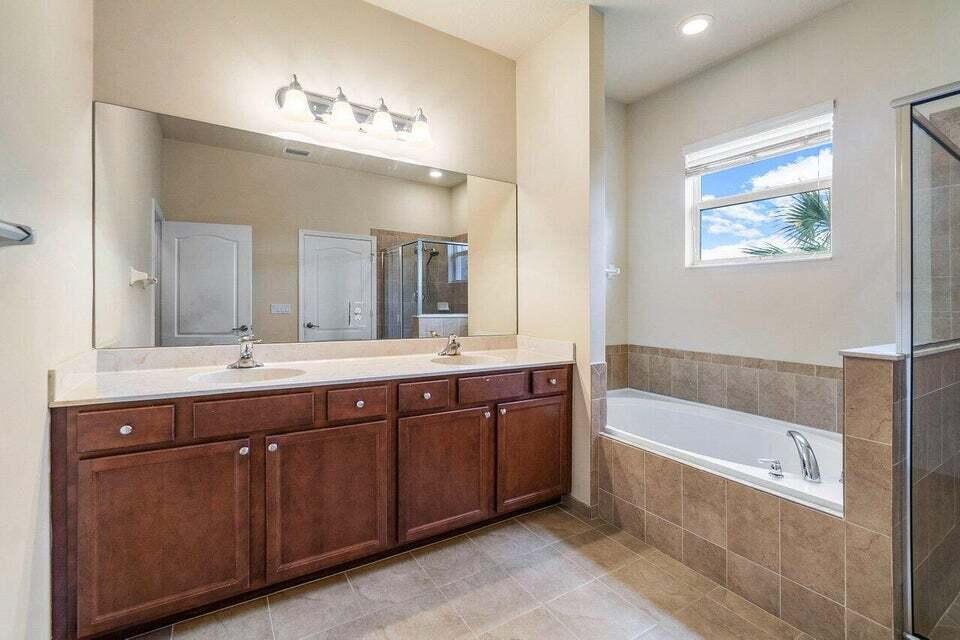 107 Chub Cay Way Jupiter, FL 33458 - Photo 12 of 15 a spacious bathroom with a tub double sink and mirror