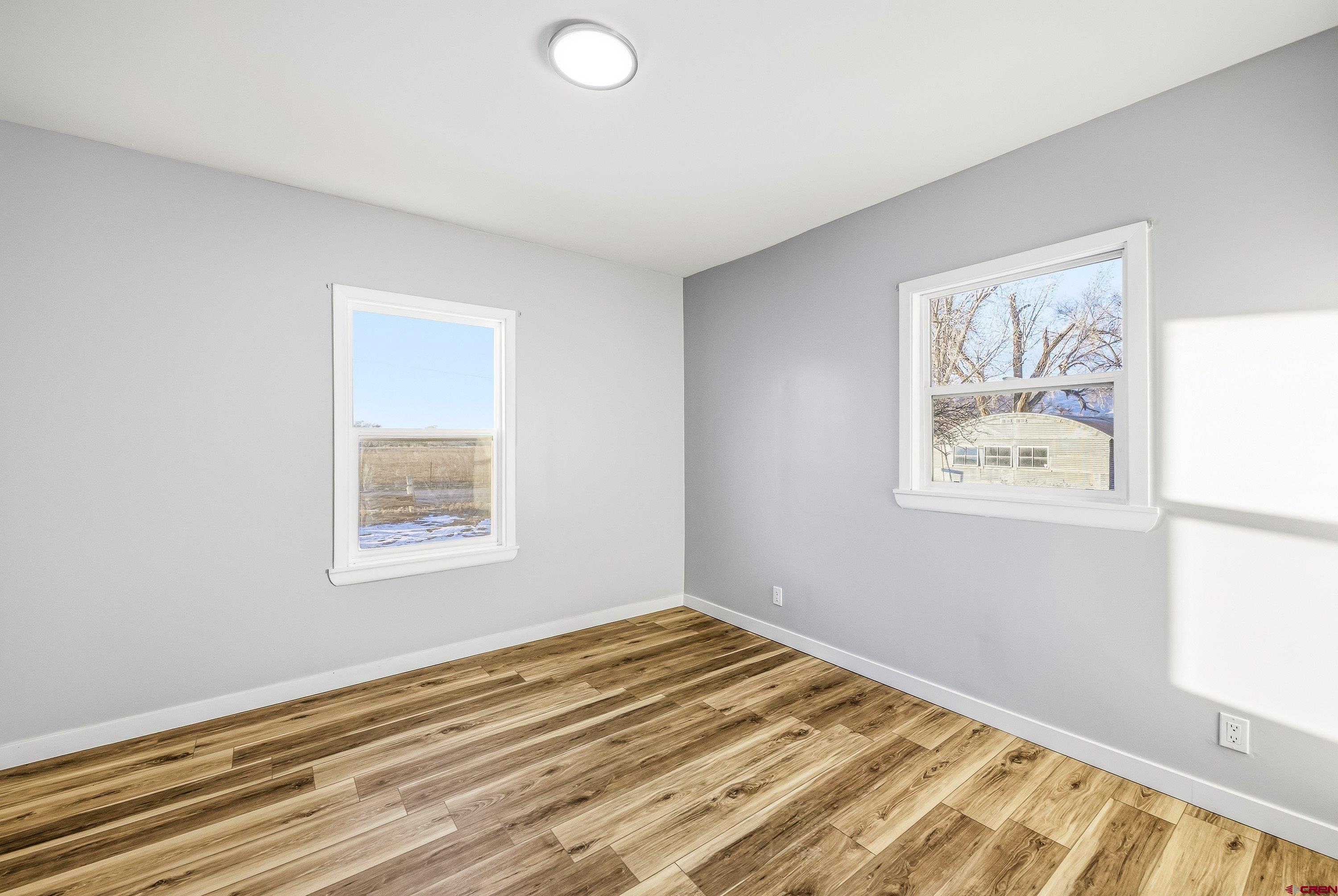 6038 Townsend Road Delta, CO 81416 - Photo 23 of 45 a view of an empty room with wooden floor and a window