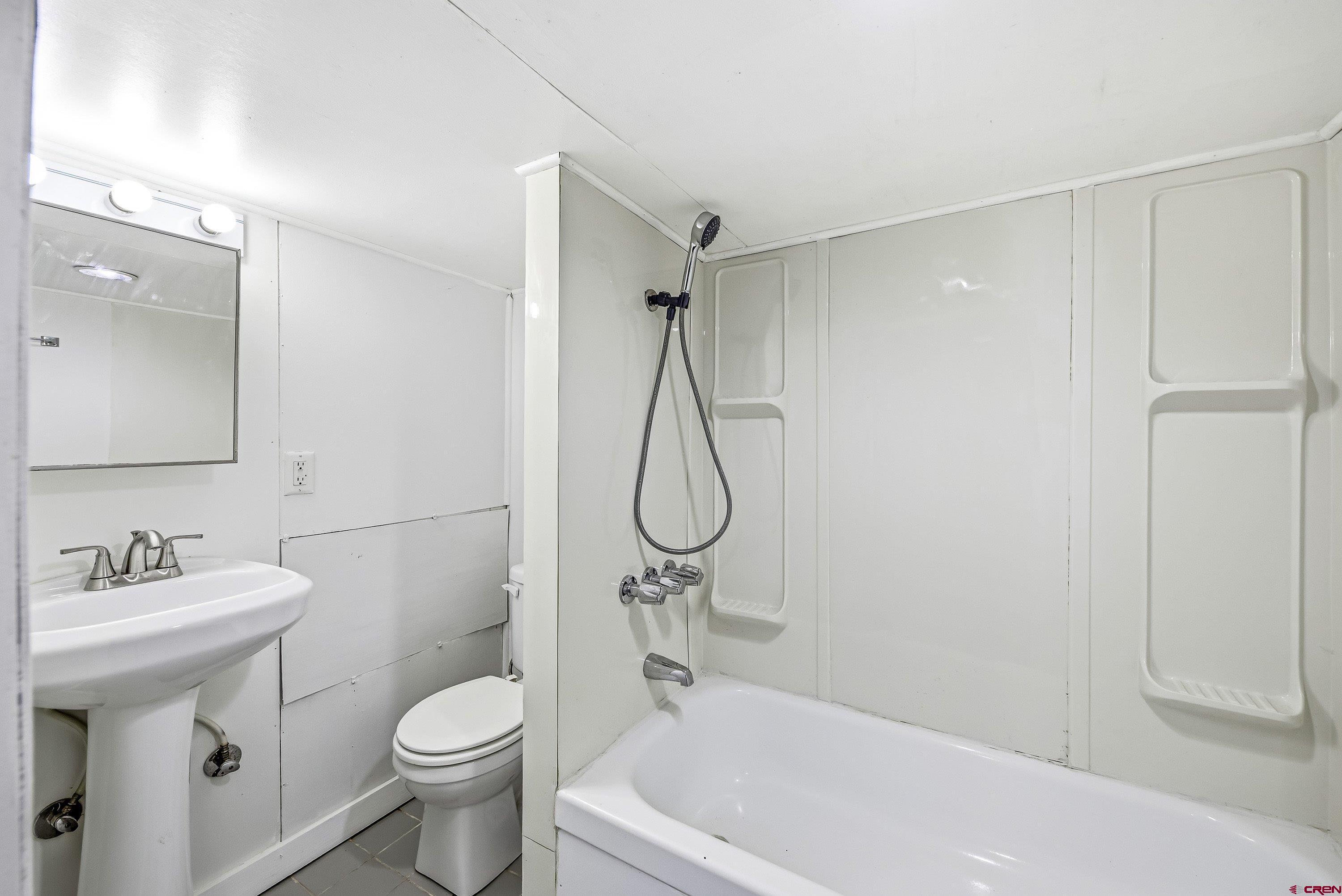 6038 Townsend Road Delta, CO 81416 - Photo 10 of 45 a bathroom with a granite countertop sink a toilet and shower