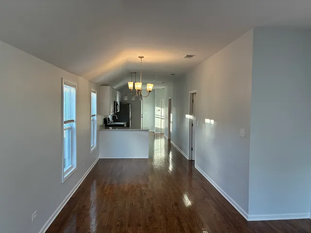 a view of a hallway with wooden floor a living room