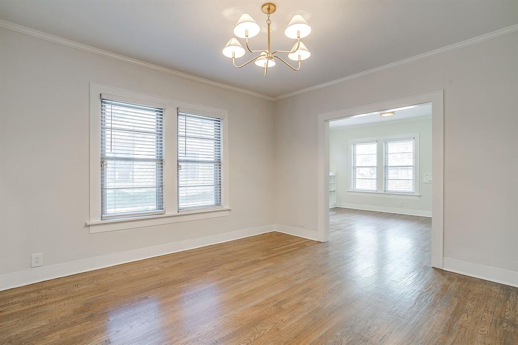 2209 West Rosedale Street South Fort Worth, TX 76110 - Photo 12 of 40 a view of an empty room with wooden floor and a window