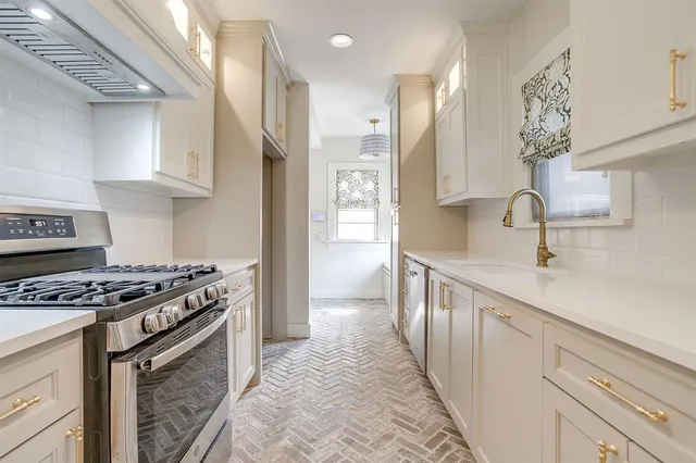 a kitchen with stainless steel appliances a sink stove and cabinets