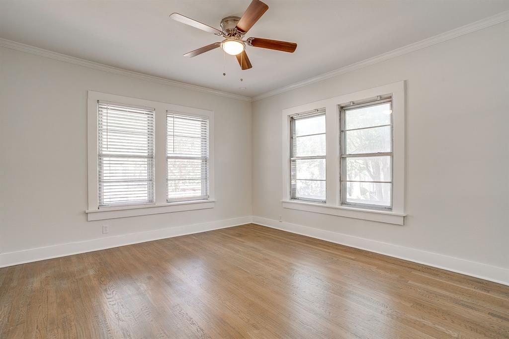 2209 West Rosedale Street South Fort Worth, TX 76110 - Photo 32 of 40 a view of an empty room with chandelier fan and wooden floor