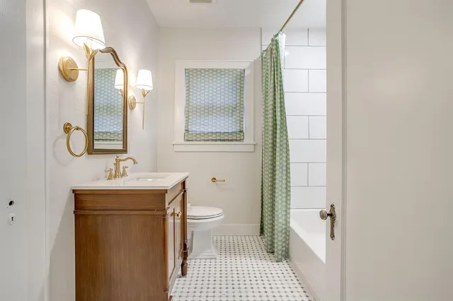 a bathroom with a sink a toilet and a mirror