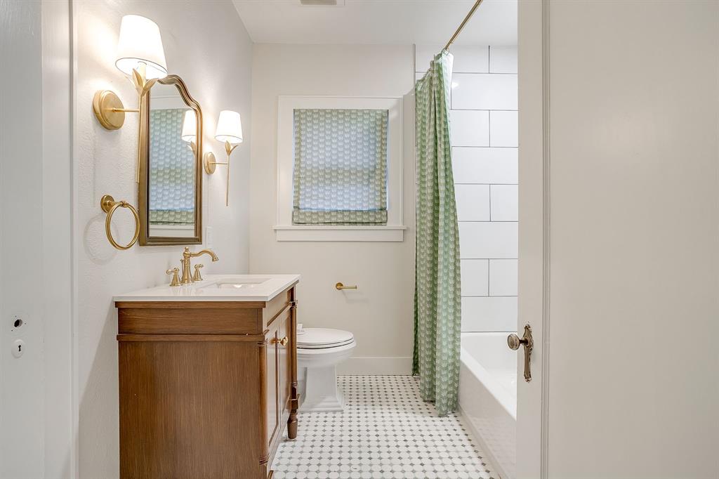 2209 West Rosedale Street South Fort Worth, TX 76110 - Photo 34 of 40 a bathroom with a sink a toilet and a mirror