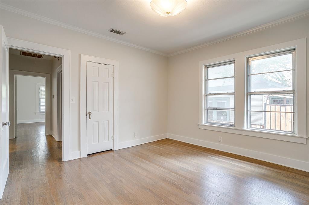 2209 West Rosedale Street South Fort Worth, TX 76110 - Photo 38 of 40 a view of an empty room with wooden floor and a window