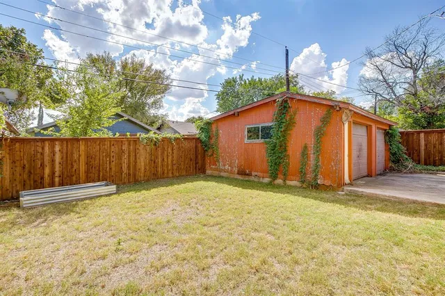 a view of backyard with wooden fence and large trees