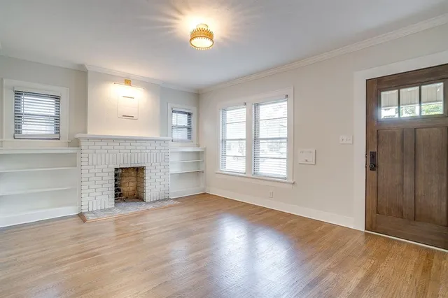 an empty room with windows and a fireplace