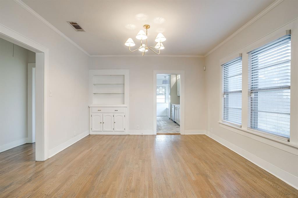 2209 West Rosedale Street South Fort Worth, TX 76110 - Photo 10 of 40 an empty room with wooden floor chandelier and windows