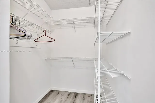 a view of walk in closet with empty racks