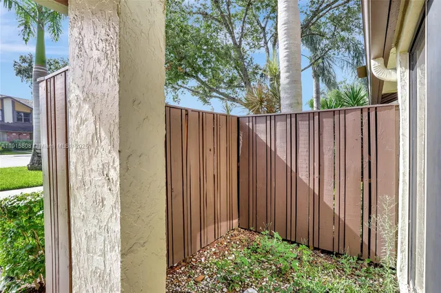 a front view of a house with a yard and potted plants