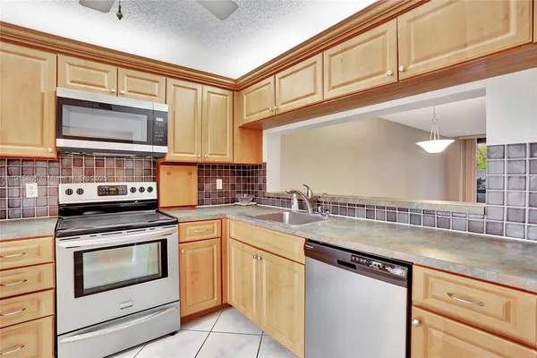 a kitchen with stainless steel appliances granite countertop a sink and cabinets