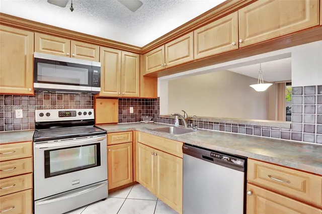 a kitchen with stainless steel appliances granite countertop a sink and cabinets