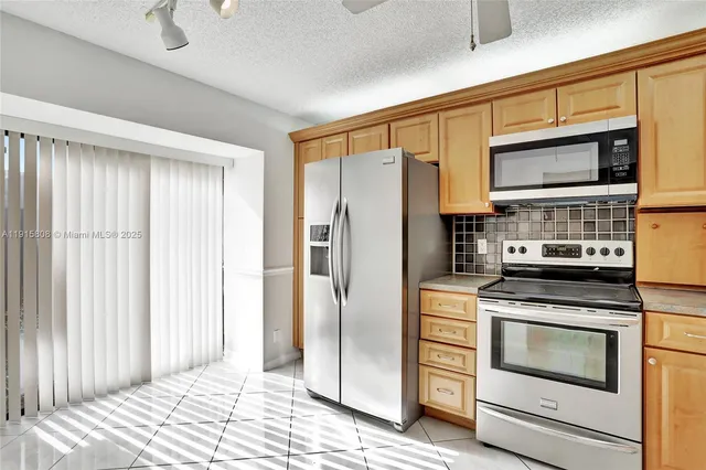 a kitchen with stainless steel appliances granite countertop a refrigerator stove and cabinets