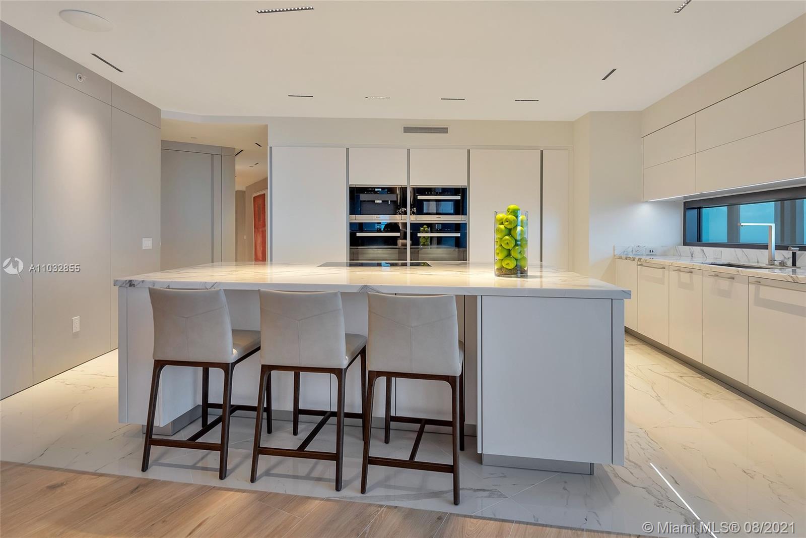North Biscayne Beach Sunny Isles Beach, FL 33160 - Photo 15 of 52 a kitchen with a dining table chairs and refrigerator