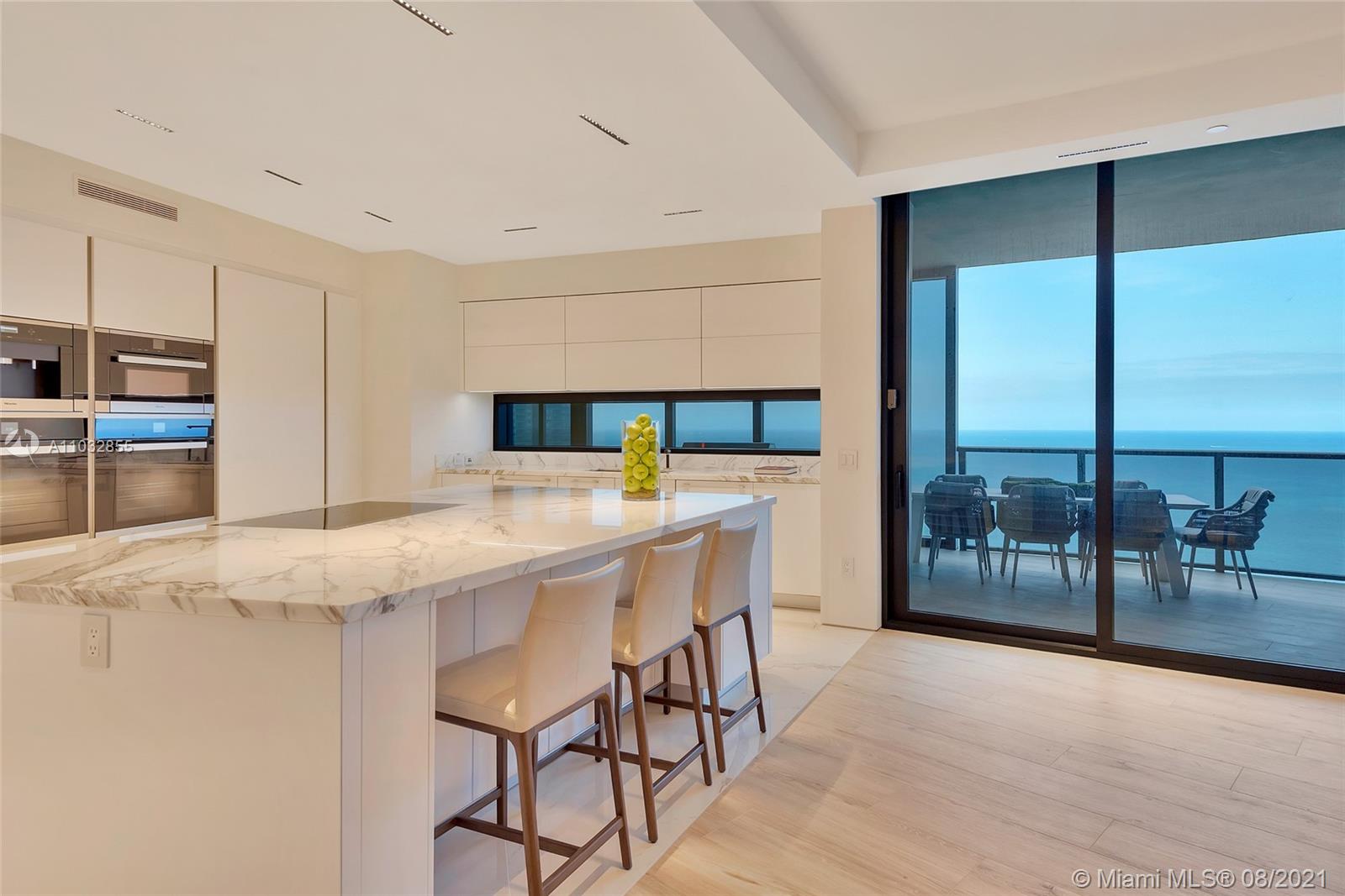 North Biscayne Beach Sunny Isles Beach, FL 33160 - Photo 4 of 52 a kitchen with stainless steel appliances granite countertop wooden floor window dining table and chairs