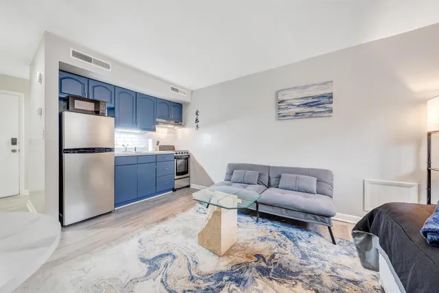 a living room with furniture and a refrigerator
