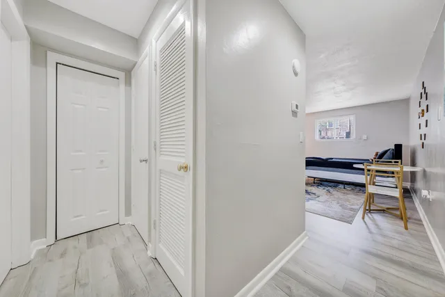 a view of a hallway to a livingroom with furniture