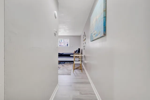 a hallway with a white cabinets and wooden floor