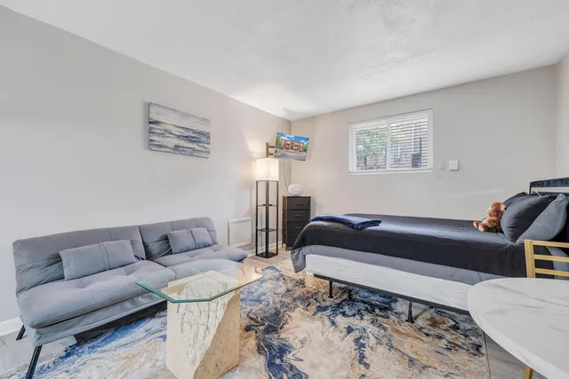 a living room with a couch and a dresser with wooden floor