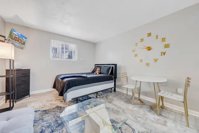 a bedroom with a bed and a lamp with the dresser