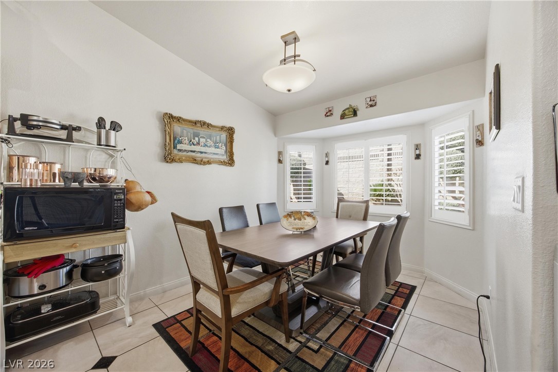 6109 Ocho Rios Street Las Vegas, NV 89130 - Photo 12 of 36 Dining space with vaulted ceiling, light tile patterned floors, and plenty of natural light