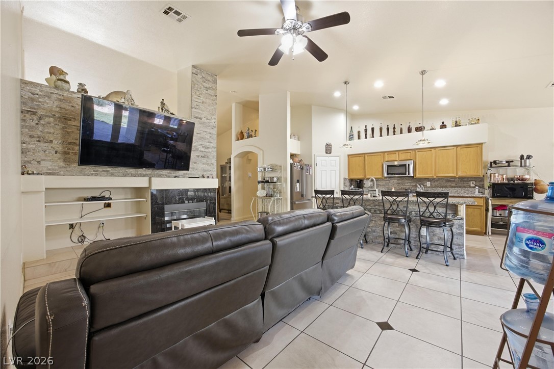 6109 Ocho Rios Street Las Vegas, NV 89130 - Photo 13 of 36 Living area featuring ceiling fan, light tile patterned flooring, arched walkways, and vaulted ceiling