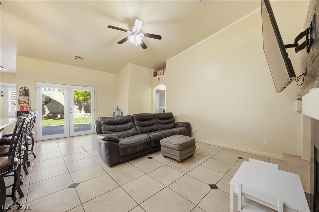 6109 Ocho Rios Street Las Vegas, NV 89130 - Photo 14 of 36 Living room with ceiling fan, arched walkways, vaulted ceiling, french doors, and light tile patterned flooring