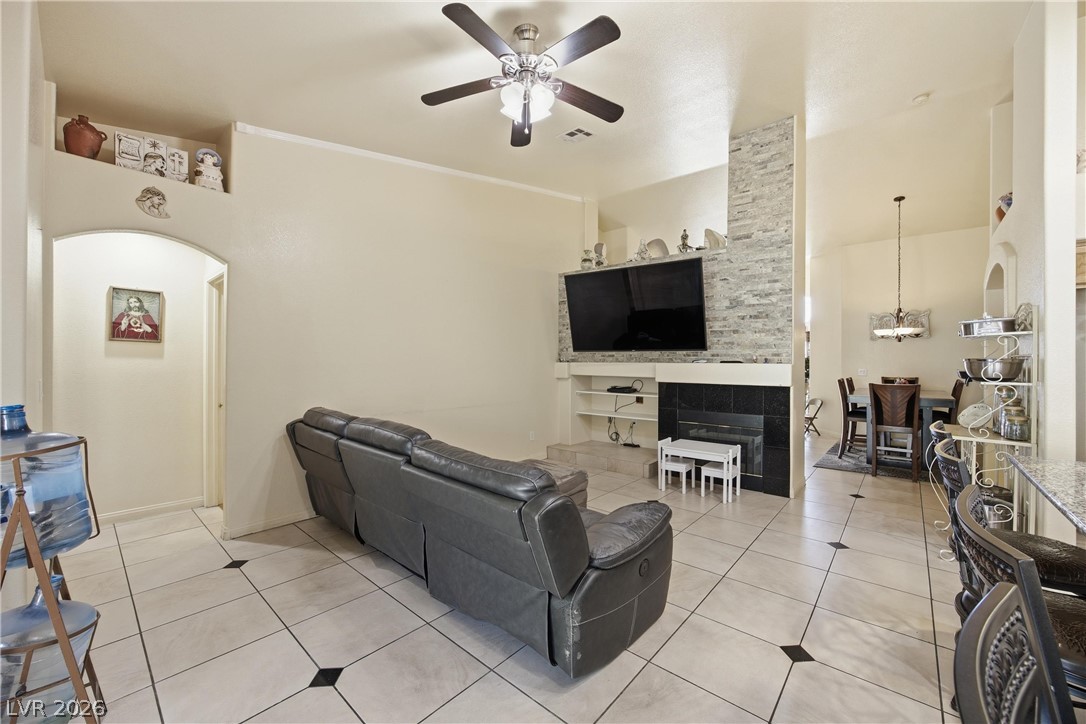 6109 Ocho Rios Street Las Vegas, NV 89130 - Photo 15 of 36 Living room with arched walkways, light tile patterned floors, ceiling fan, built in features, and ornamental molding